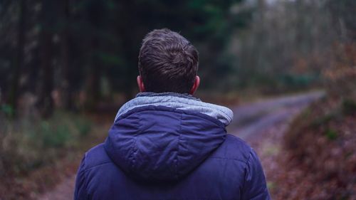 Rear view of man in forest during winter