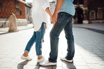 Low section of couple walking on street
