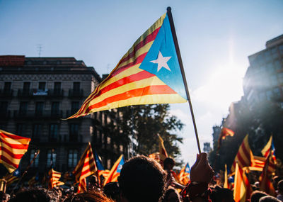 Crowd with flags against clear sky