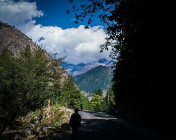 Man on mountain road against sky