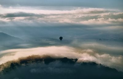 Hot air balloon flying over land against sky