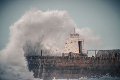 Panoramic view of building by sea against sky