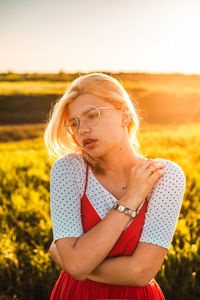 Midsection of woman wearing hat standing on field