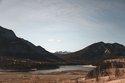 Scenic view of lake by mountains against sky