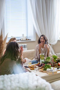 Young woman sitting on table at home