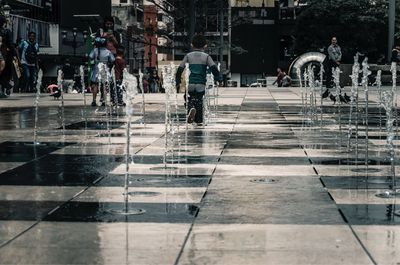 Children at fountains on street in city