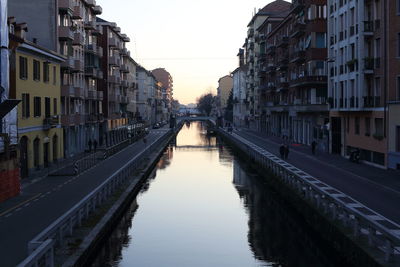 Canal amidst buildings against sky in city