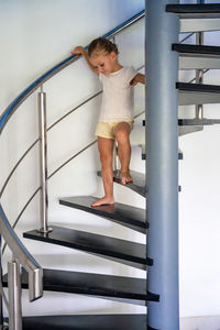 Full length of young woman standing on escalator