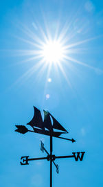 Low angle view of sun against blue sky