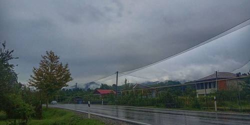 Road by buildings against sky