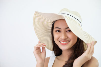 Young woman wearing hat against white background