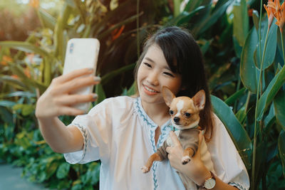 Young woman photographing with dog