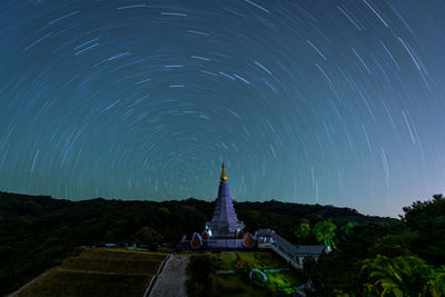 Temple against star trails at night
