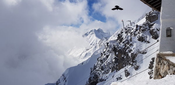Low angle view of snow covered mountain against sky
