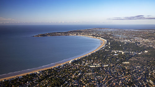 High angle view of townscape by sea against sky