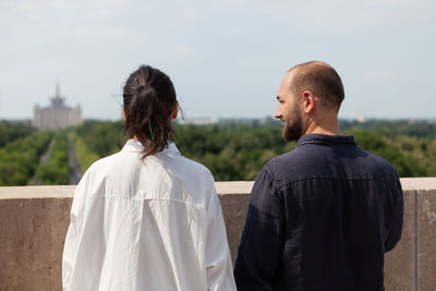 Rear view of couple standing against sky