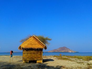 Built structure on beach against clear blue sky