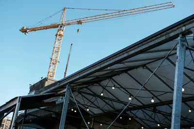 Low angle view of crane against clear sky