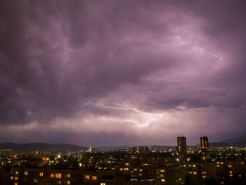 Illuminated cityscape against sky at night