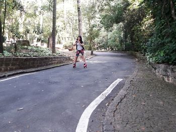 Full length of woman riding bicycle on road