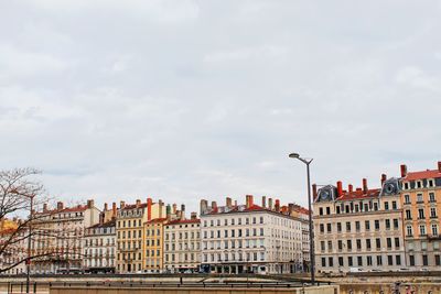 Low angle view of buildings against cloudy sky