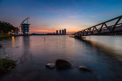 Bridge over river at sunset