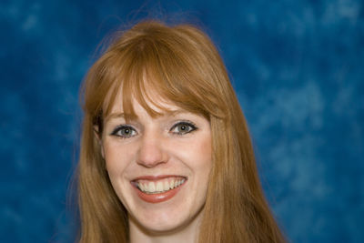 Close-up portrait of redhead woman against wall