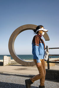 Man standing on sea shore against clear sky