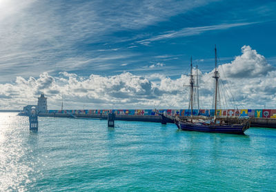 Sailboats in sea against sky