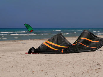 Deck chairs on beach against clear sky