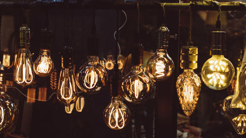 Close-up of illuminated lights hanging at shop