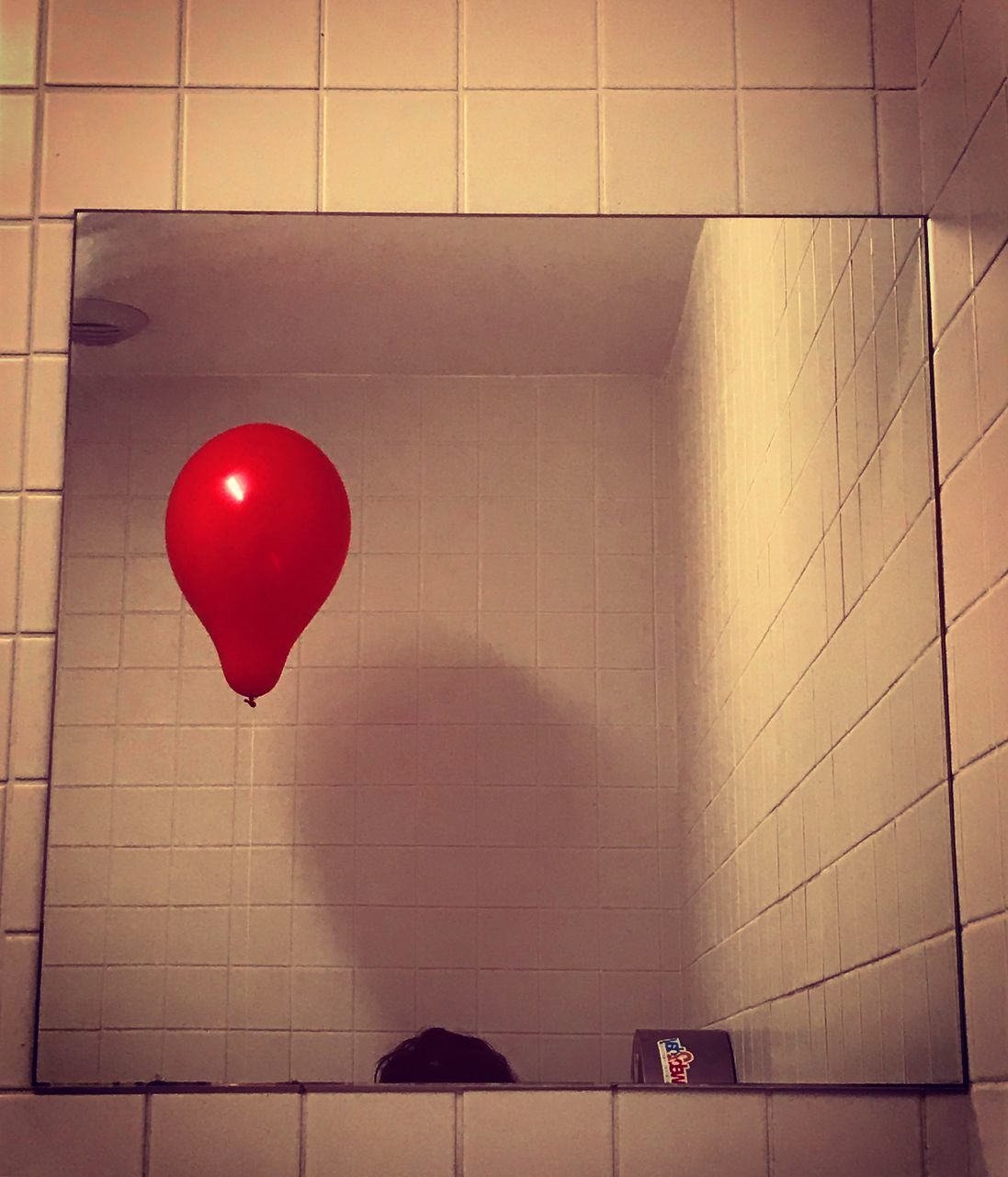 RED BALLOON ON TILED WALL