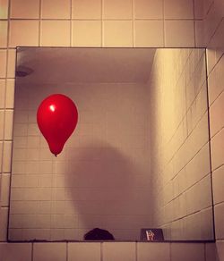 Red balloons on wall