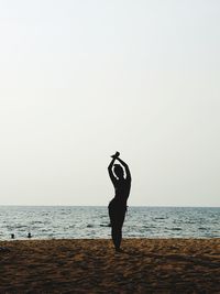 Full length of man on beach against clear sky