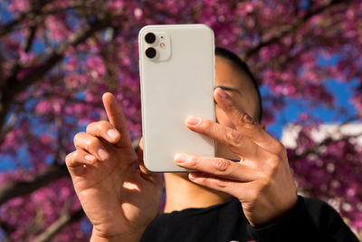 Woman using cell phone outdoors in springtime