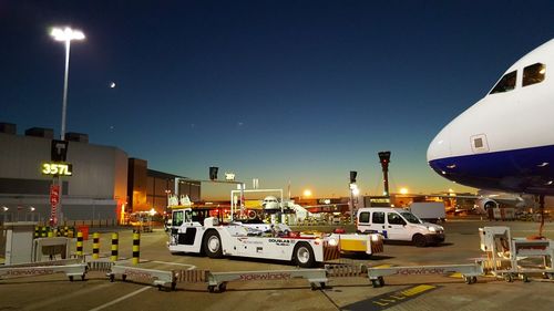 Illuminated cars against sky at night