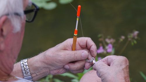 Close-up of hand holding fishing hook