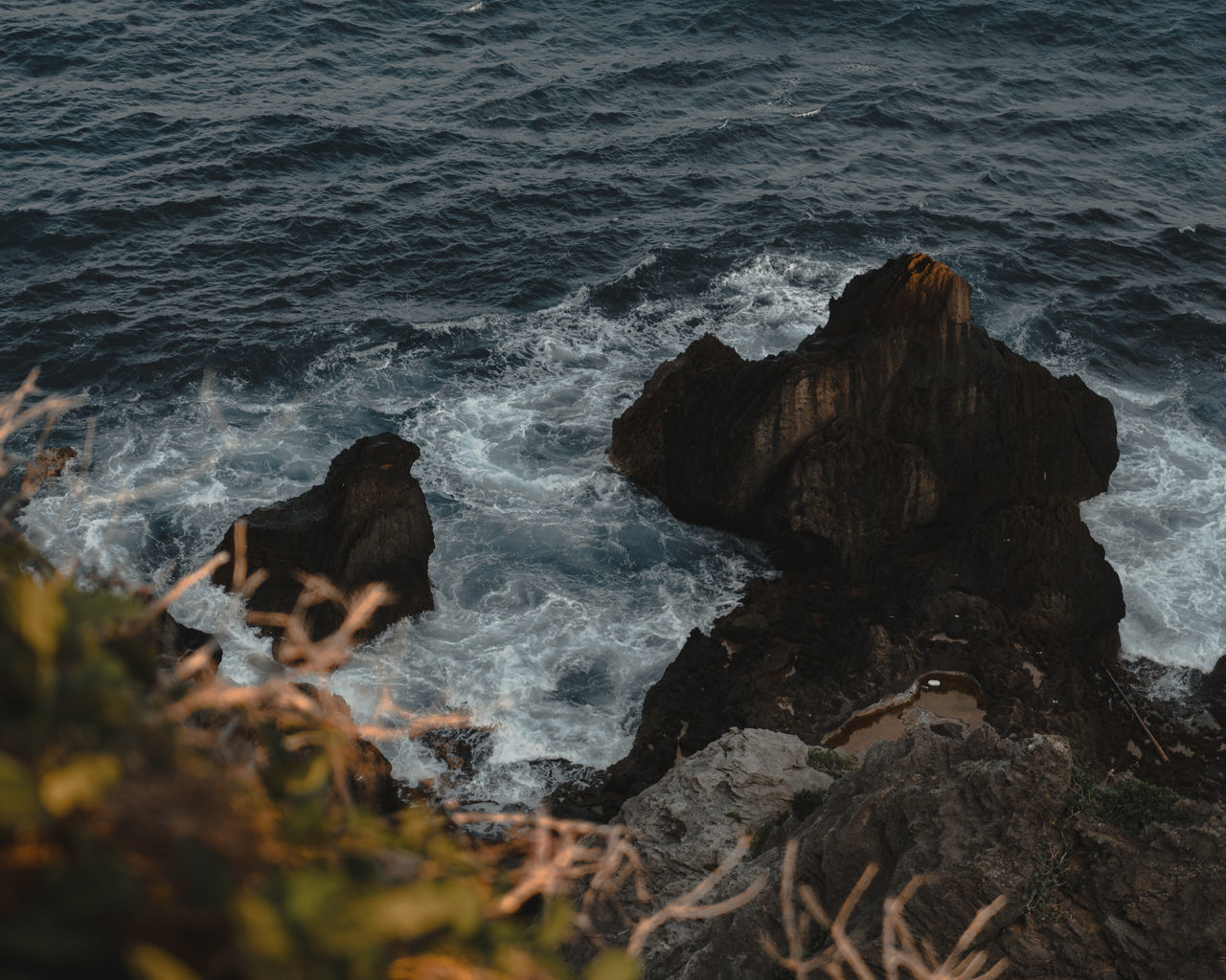 HIGH ANGLE VIEW OF ROCK FORMATIONS ON SHORE