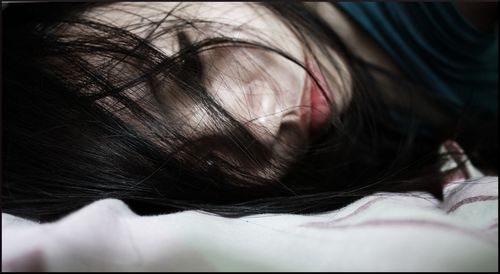 Close-up of woman sleeping on bed
