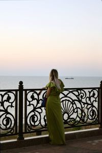 Woman looking at sea against sky