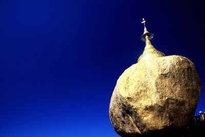 Low angle view of cross against clear blue sky