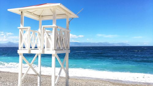 Lifeguard hut on beach against blue sky