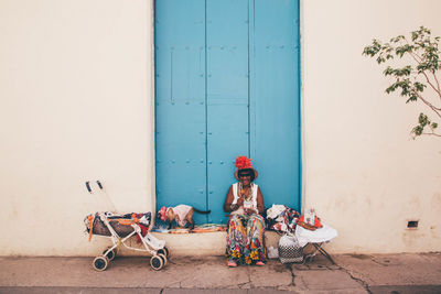 Full length of woman sitting by toy building