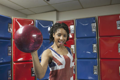 A young women holding a bowling ball.