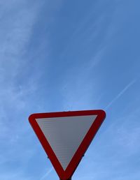 Low angle view of road sign against blue sky