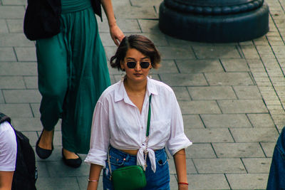 Full length of man wearing sunglasses standing on footpath