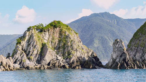 Scenic view of sea and mountains against sky