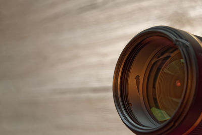 Close-up of camera lens against wooden background