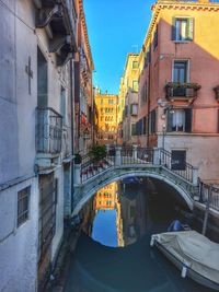 Bridge over canal amidst buildings in city