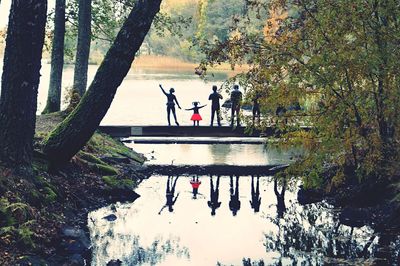 People on riverbank against sky